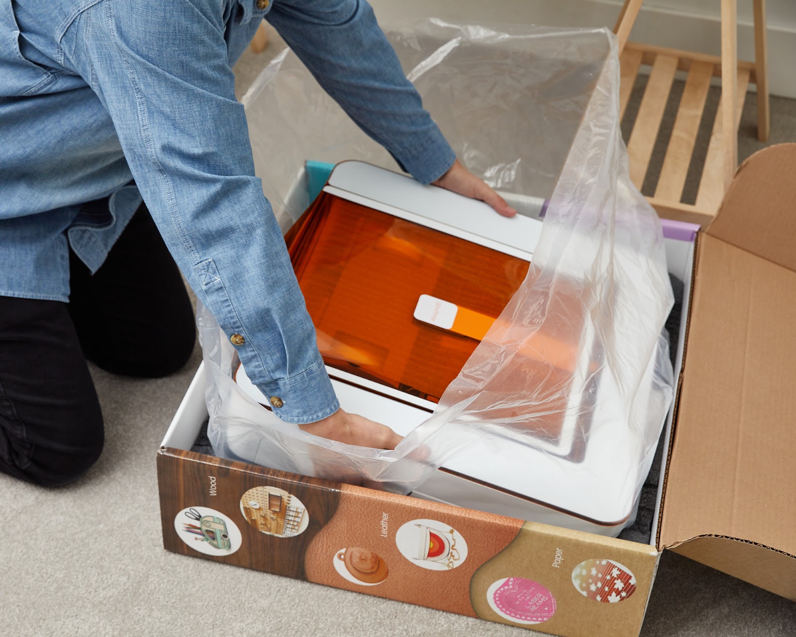 Photo of the Aura, in plastic wrap, being lifted out of the box or being held.jpg