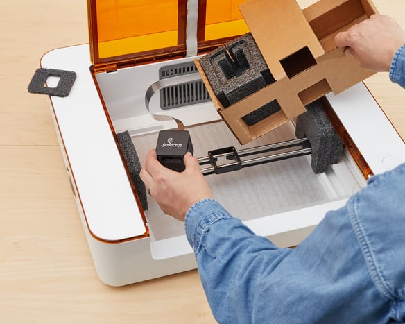 Action shot; laser head being held in one hand, top cardboard insert being removed with the other.jpg