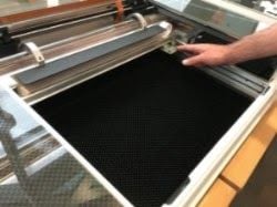 Glowforge with its lid open and arm pushed to the back of the unit