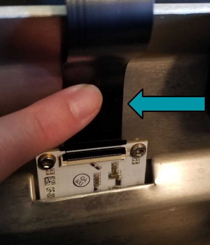 A finger pressing the cable down to stick down the adhesive