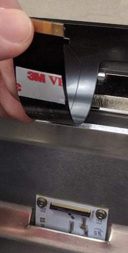 Central cable arm with adhesive backing