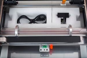 Packaging foam in the back of a Glowforge with the print head inside the foam