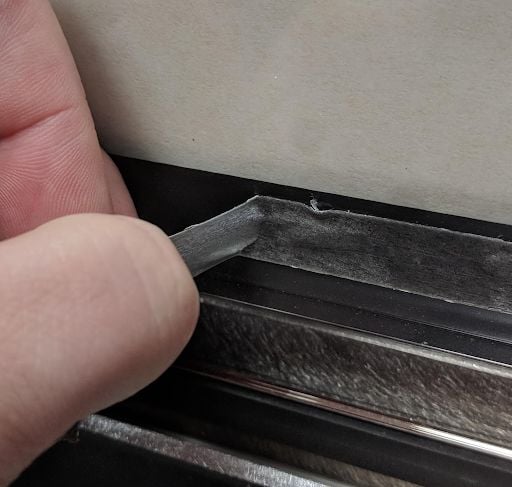 Left over adhesive being peeled off of the Glowforge lid interior