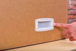 A hand using the index finger to push the tab on the right side of the handle lock into place