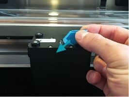 The mirror is partially inserted into the print head. The flat side of the handle with the Glowforge logo embossed onto it is parallel with the top of the print head.