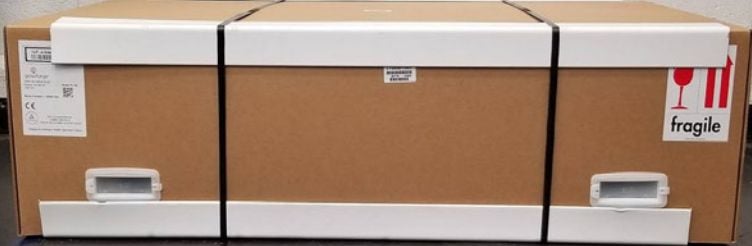 A Glowforge in its box with packing straps around it