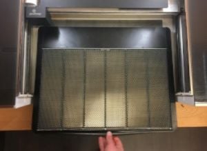Hand sliding crumb tray into Glowforge