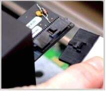 A hand holding the print head cable removed from the head
