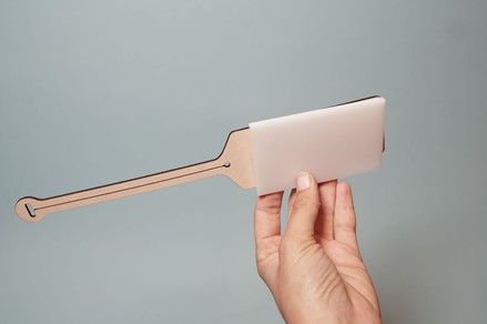 A blank leather luggage tag sandwiched between a lasercut stamp and a blank piece of acrylic