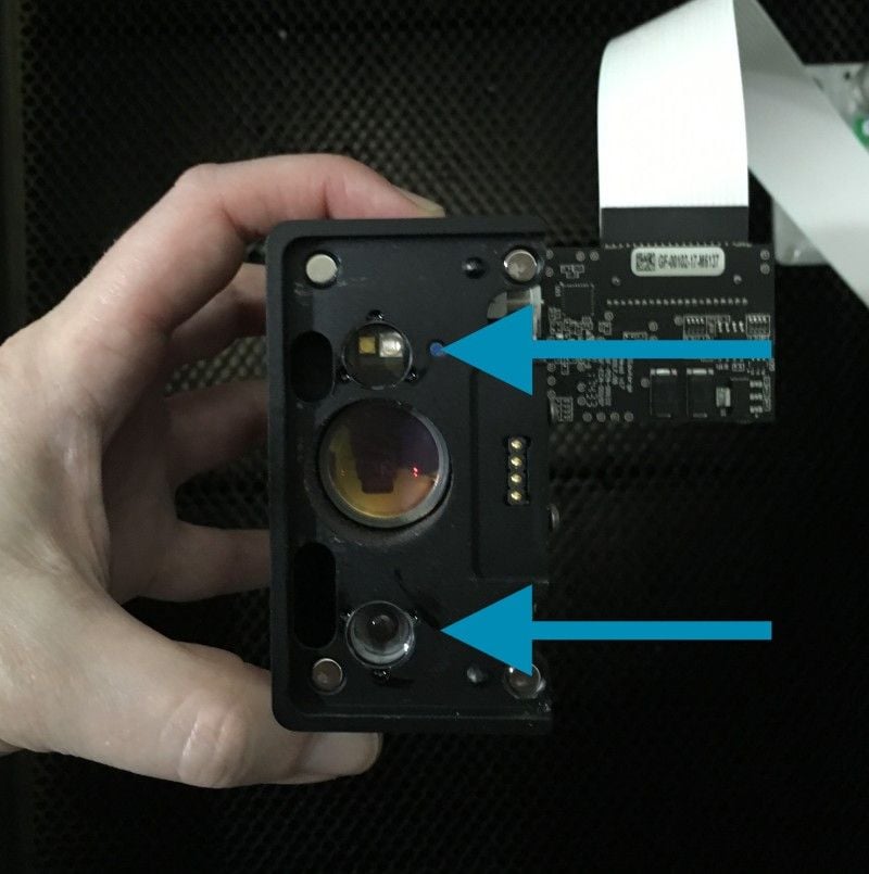 The bottom of the print head. Arrows are pointing to the windows on  the left and right on the bottom of the head.