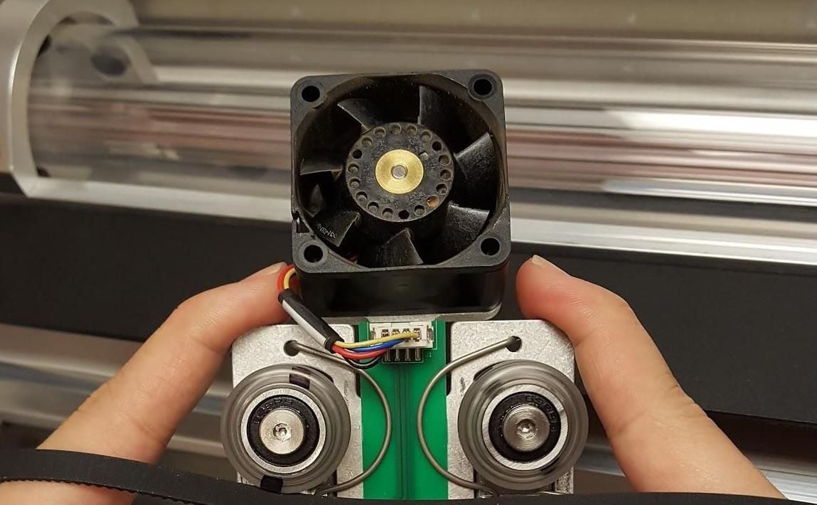An image of the air assist fan, located on the back of the carriage plate behind the two large v-wheels.