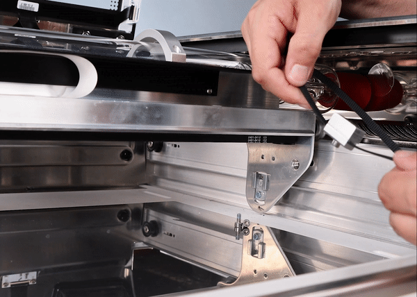 An animated gif of two hands holding a belt with its clamp between the hands and the set screw facing up