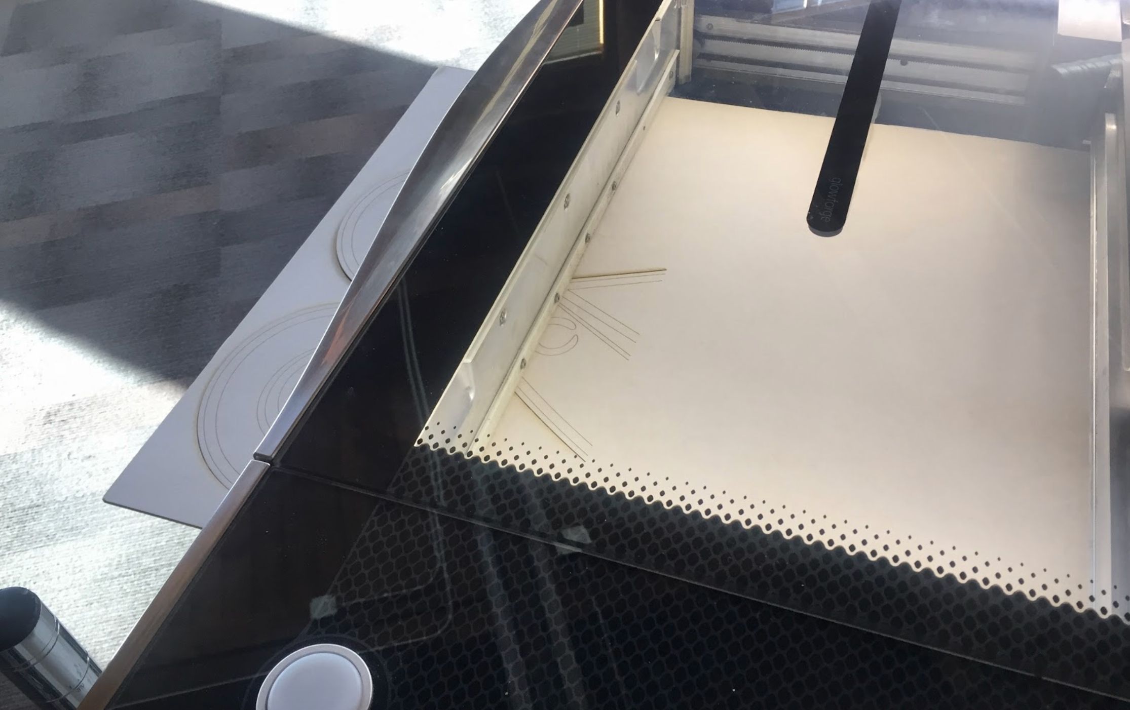 Material that has been moved through the Glowforge Pro, with the already printed portion now sticking out of the front Pro Passthrough slot.