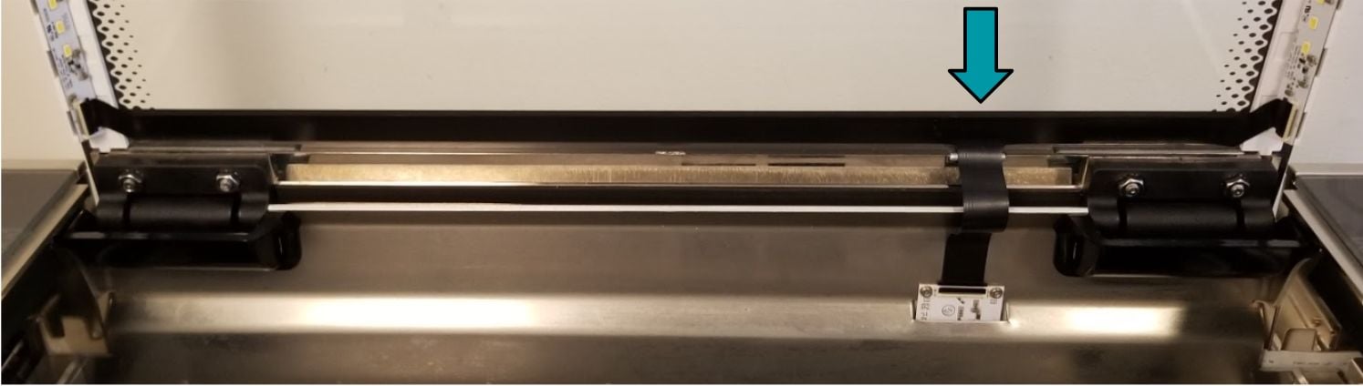 Black lid cable oriented at the base of the lid, with it's longest arm facing left and shortest arm downward
