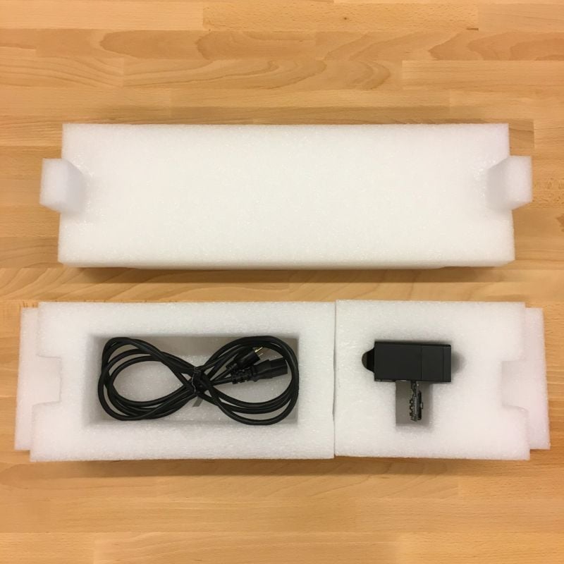 The Glowforge print head and power cord placed into their protective foam for transport