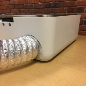 Exhaust hose installed with a ring clamp on the back of the Glowforge